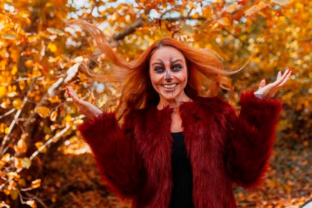 Happy woman with Halloween make-up standing in forest model released Symbolfoto MRRF01489