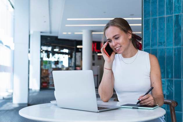 Female graphic designer talking on mobile phone in coffee shop model released Symbolfoto property released PNAF02353