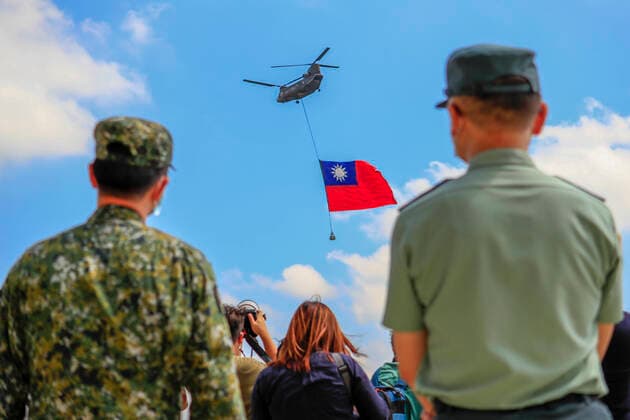Huge Flag Flyover Rehearsal Ahead Of National Day Celebration Taiwanese soldiers stand guard as a Chinook Helicopter carrying a tremendous Taiwan flag flies over a military camp, as part of a rehearsal for the flyby performance for Taiwan™s Double-Ten National Day Celebration, amid rising tensions between Beijing and Taipei and threats from China, in Taoyuan, Taiwan 28 September 2021. The 18-meter wide and 12-meter long Taiwan flag, according to state media Central News Agency, will be carried by two CH-47 Chinook helicopters flag flying over the Presidential Building on October 10, whilst the island has been developing better ties with the US, UK, Australia, and other European countries such as Lithuania, Czech Republic and Poland. Taoy Copyright: xCengxShouxYix