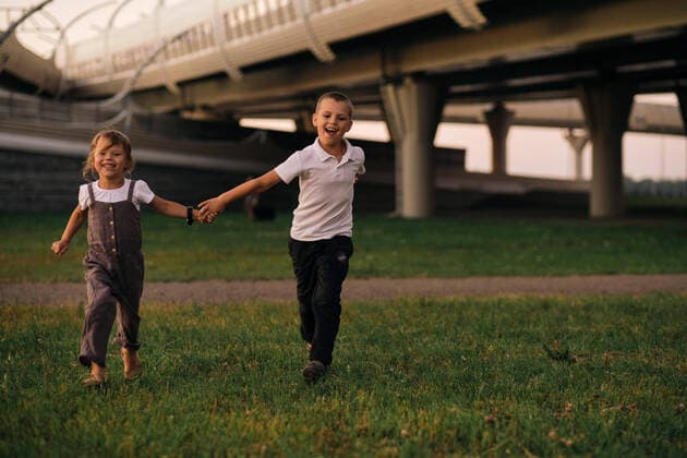Children, boy and girl, holding hands, run at sunset under the bridge. Saint Petersburg, ?????-?????????, Russia CR_XGWK210906-828483-01 ,model released, Symbolfoto