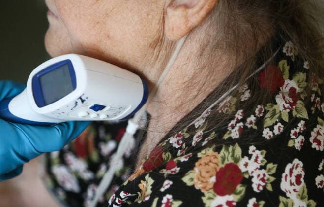 KEMEROVO, RUSSIA - OCTOBER 1, 2021: A medical worker measures a patient s body temperature at the Kemerovo regional clinical hospital for war veterans repurposed to attend COVID-19 patients. Maxim Kiselev TASS  TS112B1D