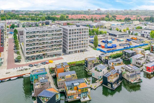 IMAGO Creative, Jahreszeit Sommer, Sommer in der Stadt Drone view of contemporary building facades against pier and houseboats on rippled river in Amsterdam Netherlands CasaMedia_Fonteinkruidstraat56_1.jpg Copyright: xCasaxMediax Model Released
