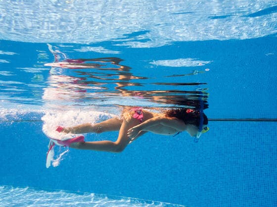 Side view of child in swimwear and goggles with snorkel looking at camera while swimming in rippled pool, Model released RaulMellado_Lanzarote_090.jpg Copyright: xRaulxMelladox MR