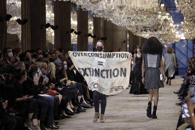 Bilder des Jahres 2021, Entertainment 10 Oktober Entertainment Themen der Woche KW40 Entertainment Bilder des Tages A green activist parades on the catwalk holding a banner that reads : ÇÊoverconsumption equals extinctionÊÈ during Louis Vuitton s Spring-Summer 2022 show at Paris Fashion Week, on Tuesday, October 5, 2021.  PAR20211005101 ECOxCLEMENT