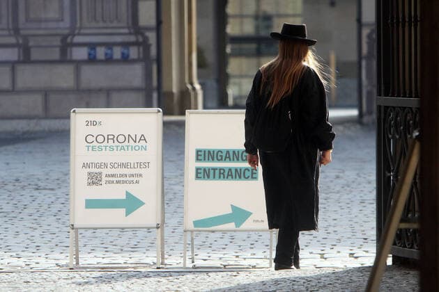 Aufsteller mit Aufschrift Corona Teststation Antigen Schnelltest 21DX mit Richtungspfeil steht in der Innenstadt von München, Bayern, Deutschland