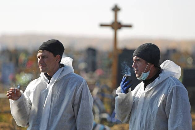 OMSK, RUSSIA â€“ OCTOBER 9, 2021: Cemetery workers in protective gear are seen during the funeral of a person who died of a cause related to COVID-19 at Novo-Yuzhnoye Cemetery. Yevgeny Sofiychuk TASS  TS11395E