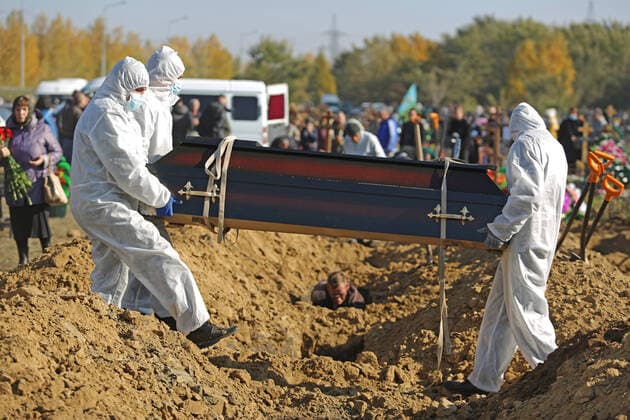 OMSK, RUSSIA â€“ OCTOBER 9, 2021: Cemetery workers in protective gear bury people who died of causes related to COVID-19 at Novo-Yuzhnoye Cemetery. Yevgeny Sofiychuk TASS  TS113960