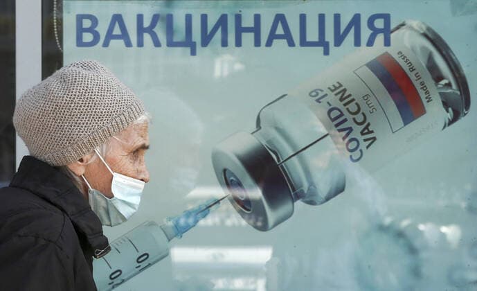 SIMFEROPOL, CRIMEA, RUSSIA - OCTOBER 12, 2021: An elderly woman walks past a mobile vaccination site at the Yuzhnaya Galereya Southern Gallery shopping mall offering COVID-19 vaccines. Sergei Malgavko TASS  TS113DA3