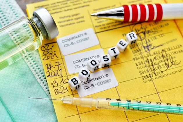 Impfpass mit drei eingetragenen Corona-Impfungen und Schriftzug Booster, Symbolfoto Booster-Impfung