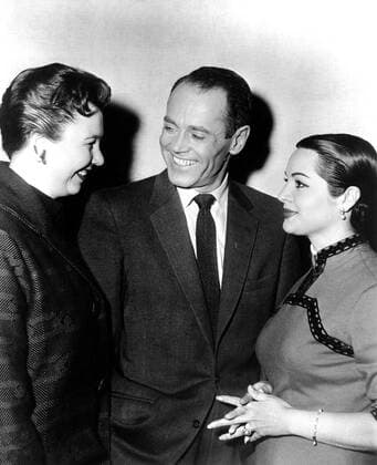 THE WRONG MAN, Henry Fonda, center, being visited on-set by Jane Withers (left, filming GIANT), and Sarita Montiel (right, filming SERENADE), 1956 Ref:MBDWRMA EC052 PUBLICATIONXNOTxINxCANxCHNxFRAxITAxJPNxNORxPOLxRUSxESPxUKxUSA Copyright: xx MBDWRMA EC052
