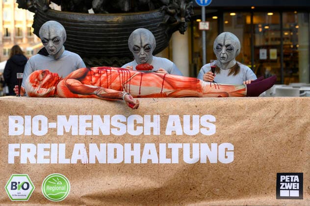 Als Aliens verkleidete Aktivisten der Tierschutzorganisation PETA essen einen Bio-Mensch aus Freilandhaltung bei einer Protestaktion gegen Speziesismus. Nürnberg, 13.10.2021 *** Activists of the animal rights group PETA dressed up as aliens eat a free-range organic human at a protest against speciesism Nuremberg, 13 10 2021 Foto:xD.xAnoraganingrumx xFuturexImage