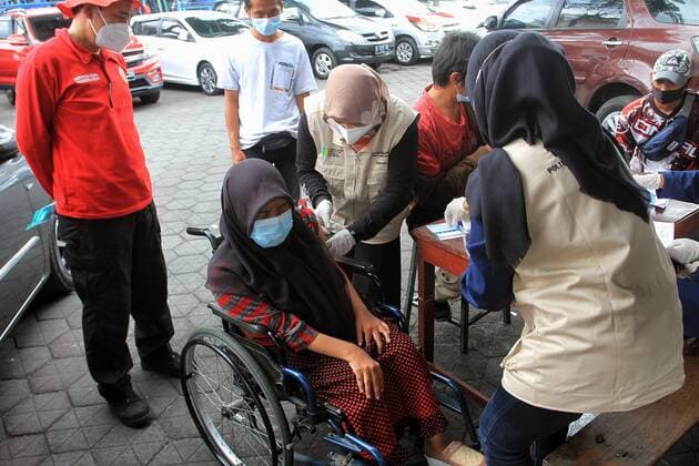 Covid-19 Vaccination In Indonesia A health worker inject of the Sinovac Covid-19 vaccine into a street vendors during a vaccination program at the Beringharjo Market in Yogyakarta, Indonesia, on October 14, 2021. Indonesia has inoculated over 100 million people so far, the most in Southeast Asia, is also possible on the prepare reopening tourism for foreign tourists amid the Covid-19 pandemic. (Photo by Devi Rahman INA Photo Agency Sipa USA) 