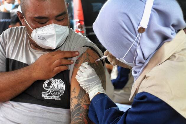 Covid-19 Vaccination In Indonesia A health worker inject of the Sinovac Covid-19 vaccine into a street vendors during a vaccination program held by the Indonesian Intelligence Agency at the Beringharjo Market in Yogyakarta, Indonesia, on October 14, 2021. Indonesia has inoculated over 100 million people so far, the most in Southeast Asia, is also possible on the prepare reopening tourism for foreign tourists amid the Covid-19 pandemic. (Photo by Devi Rahman INA Photo Agency Sipa USA) 