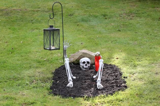 Symbolbild zum Thema Halloween, auf einer Wiese vor einem Haus in Kreuztal wurde Halloween-Deko aufgebaut, Grab mit Skelett Symbolbild, Halloween, am 13.10.2021 in Kreuztal Deutschland. *** Symbolic picture about Halloween, on a meadow in front of a house in Kreuztal Halloween decoration was built, grave with skeleton symbolic picture, Halloween, on 13 10 2021 in Kreuztal Germany