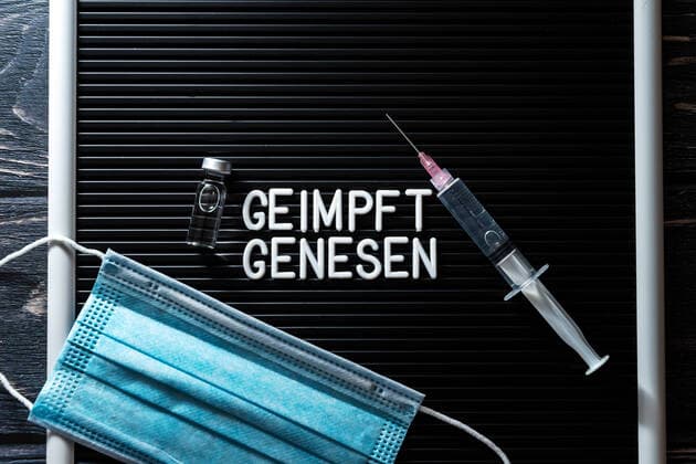 Schild mit der Aufschrift, Geimpft und Genesen, Symbolbild für 2G Regel, 2G-Regel in Deutschland schließt getestet und ungeimpfte Personen aus. Schild mit Spritze, Test und Maske