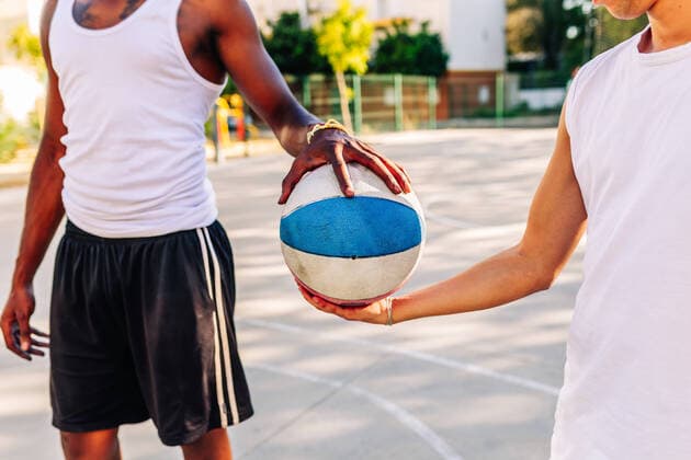 IMAGO Creative: Sport in der Stadt Crop anonymous African American male players standing with ball on basketball sports ground in summer, Model released JoseCarlosGutierrez_AfroGuyBasket_7.jpg Copyright: xJosexCarlosxGutierrezx MR