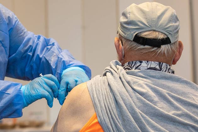 Impfteam im Einsatz Eine Krankenschwester von einem mobilen Impfteam impft einen älteren Mann in einer Sporthalle im sächsischen Pirna. Mit dem Angebot sollen auch die Menschen erreicht werden, die sich bisher nicht impfen lassen haben oder diese Möglichkeit als Auffrischung (Boosterimpfung) nutzen wollen. Pirna Sachsen Deutschland