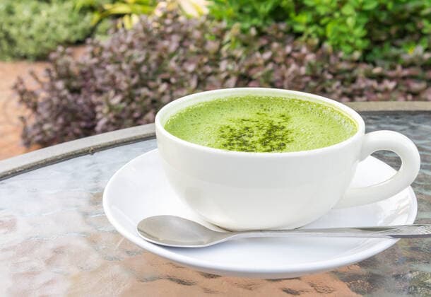 Closeup a cup of matcha latte or green tea on glass table with nature background Copyright: xx 24985618
