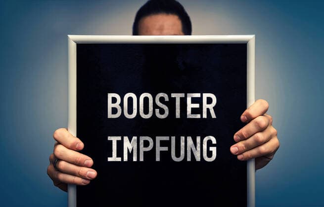 Boosterimpfung, Schild mit der Aufschrift Booster Impfung, Covid-19 Corona Virus Impfschutz durch eine Dritte Impfdosis, Drittimpfung wird Boosterimpfung genannt xFOTOMONTAGEx