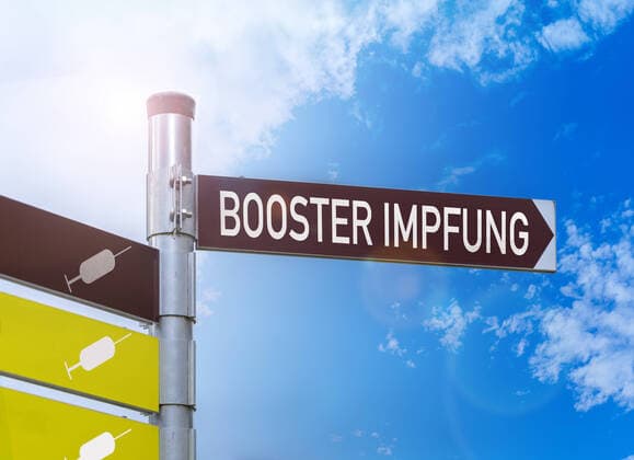 Boosterimpfung, Schild mit der Aufschrift Booster Impfung, Covid-19 Corona Virus Impfschutz durch eine Dritte Impfdosis, Drittimpfung wird Boosterimpfung genannt xFOTOMONTAGEx