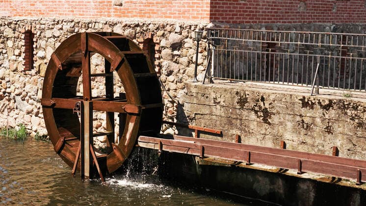 IMAGO Creative: Landleben, Mit Nachhaltigkeit grün auf dem Land leben An old water mill on the background of a brick building. An old water mill on the background of a brick building. Wooden mill near the river Copyright: xx 37876056