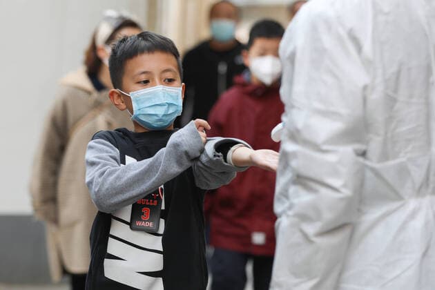 (211021) -- LANZHOU, Oct. 21, 2021 -- A student has his temperature measured before entering a temporary COVID-19 testing site at a primary school in Lanzhou, capital of northwest China s Gansu Province, Oct. 21, 2021. Lanzhou suspended in-person classes for local kindergartens, primary and high schools, and off-campus training institutions starting Thursday for COVID-19 control. Health authorities had collected 11,326 samples for nucleic acid testing from nine schools in Lanzhou, with all samples testing negative, said the information office of the provincial government. Gansu reported five locally transmitted confirmed COVID-19 cases on Wednesday, including four in Lanzhou, according to the National Health Commission. ) CHINA-GANS