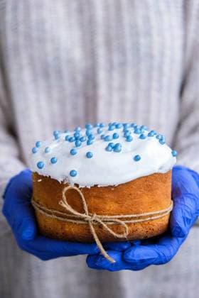 IMAGO Creative: Ostern Hands in blue gloves hold Easter cake with white topping and blue sprinkles. Woman holding traditional Russian Easter cake. Homemade pie for spring holiday celebration The cook Hands in blue gloves hold Easter cake with white topping and blue sprinkles. Woman holding traditional Russian Easter cake. Homemade pie for spring holiday celebration Copyright: xx 38513724