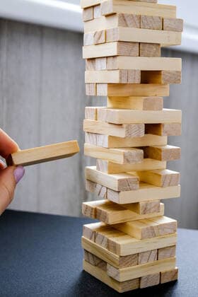 IMAGO Creative: Jahreszeit Winter, Fantasievoll drinnen spielen Building from wooden blocks. Game for family of wooden bars. Wood blocks stack game with Hand on background. Block tower with architecture model. Building from wooden blocks. Wood blocks stack game with Hand on background. Conceptual of Teamwork. Block tower with architecture model, Risk of management and strategy plan, growth business success process Copyright: xx 38530736