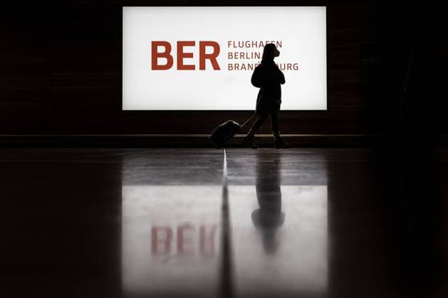 Eine Person zeichnet sich als Schattenriss vor dem Logo des Flughafen Willy-Brandt BER in Berlin, 15.10.2021. Berlin Deutschland *** A person draws himself as a silhouette in front of the logo of the airport Willy Brandt BER in Berlin, 15 10 2021 Berlin Germany Copyright: xFlorianxGaertner photothek.dex