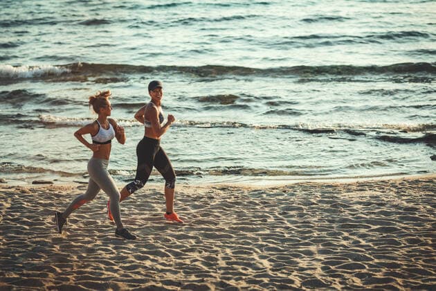 IMAGO Creative: Sommer Sport - Strand Freedom Two smiling happy young women are running along the sea shore on the beach during the hot summer vacation day. Copyright: xMilanxMarkovicx 39002194