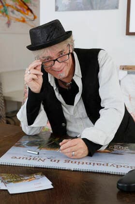Künstler Jörg Düsterwald signiert seinen Bodypainting-Kalender 2022 im Atleier Düsterwald. Bei den Motiven seines Projekts Nature Art bemalt er seine Bodyart-Fotomodelle so in Naturkulissen, dass sie damit zu einer Symbiose verschmelzen. Mit dem Projekt macht der Künstler auf die sensible, durch den Klimawandel gefährdete Natur und Umwelt aufmerksam. Hameln, 22.10.2021