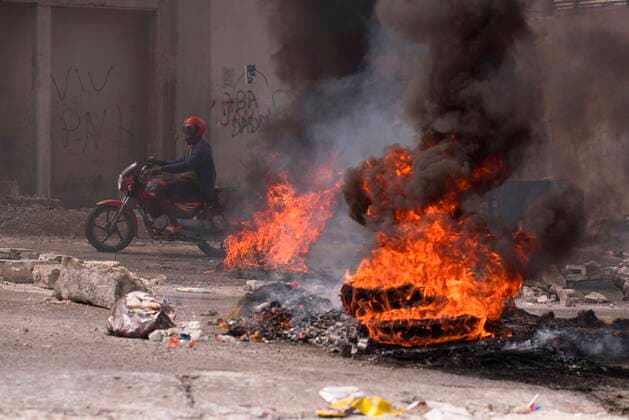 Bilder des Jahres 2021, News 10 Oktober News Themen der Woche KW42 News Bilder des Tages A man on a motorcycle passes burning barricades during a day of protests following the kidnapping of 17 foreign missionaries, 16 of them American and one Canadian, which occurred last Saturday when they were returning from an orphanage on the outskirts of the capital, in Port-au-Prince, Haiti, 23 October 2021. A week after the kidnapping the 17 people, neither the Haitian Government nor the Police have offered official information on the case, although several sources from the Executive have confirmed to the media that the detained missionaries are being held by the 400 Mawozo gang, which is asking for a ransom of 17 million dollars. In recent months, murders, robberies and kidnappings have multiplied, becoming a lucrative source of funding  Copyright: xOrlandoxBarriax AME1504 20211023-60896aab50315ce6247bf3d91518b169ebb08b9d