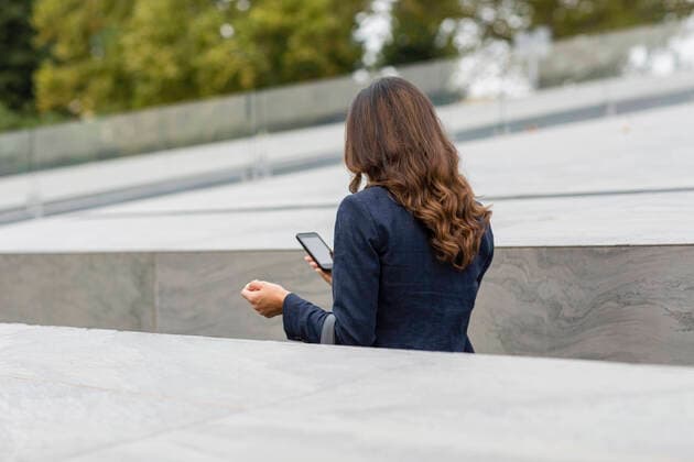 Businesswoman using mobile phone amidst retaining wall model released Symbolfoto EIF02183