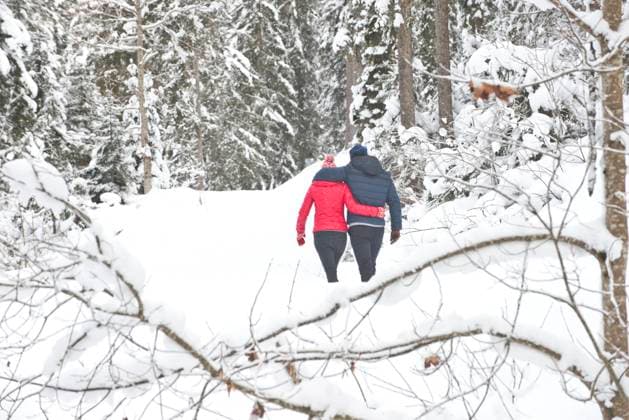 IMAGO Creative: Wintersport, Urlaub Man and woman with arm around each other walking on snow during winter model released Symbolfoto HHF05700