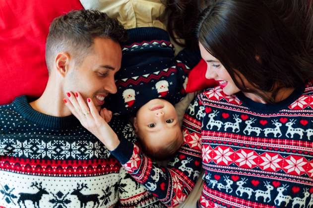 Happy family lying on bed at home during Christmas model released Symbolfoto PGF00833