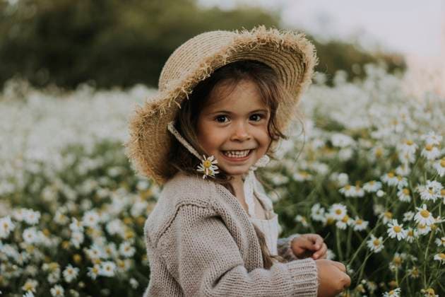 Smiling girl with flower in hat at agricultural field model released Symbolfoto SSGF00015