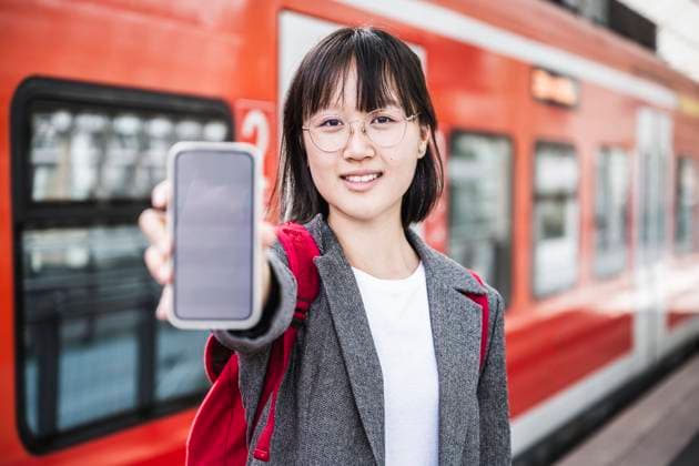 Teenage girl showing smart phone at train station model released Symbolfoto UUF24853