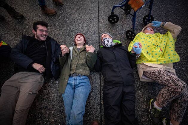 October 25, 2021, Richmond, BC, Canada: People hold hands while lying on the street during a protest organized by the environmental activist group Extinction Rebellion where they blocked the main road used to access Vancouver International Airport, in Richmond, B.C., Monday, Oct. 25, 2021. More than a dozen people were arrested and traffic to and from the airport was diverted due to the protest which was part of the group s two week October Rebellion action. Richmond Canada  - ZUMAc35_ 20211025_zaf_c35_130 Copyright: xDarrylxDyckx