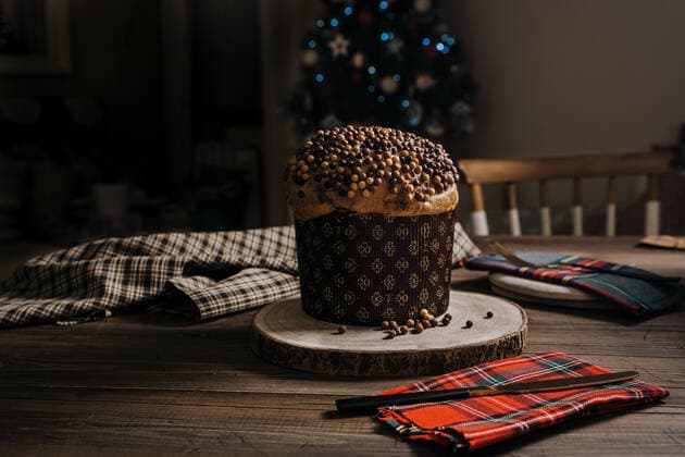Sweet homemade baked panettone on round wooden stand near knife for celebrating Christmas JayMid_XmasPanettone_1.jpg Copyright: xJayxMidx Model Released