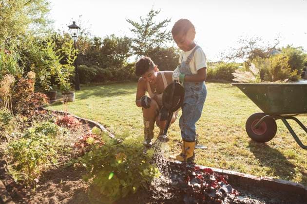 IMAGO Creative: Mutterschaft IMAGO Creative: NGO, Ausbildung für Kinder Boy watering plants with mother during sunny day Sweden, Skane, model released, property released Copyright: xMaskotx , MA89295