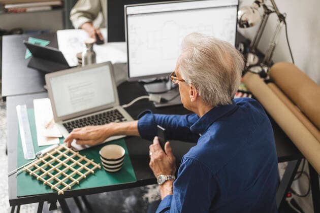 IMAGO Creative: Internationaler Tag der Architektur am 3. Oktober. Thema: Architektur zum Wohlfühlen High angle view of male entrepreneur working on laptop at office Sweden, Stockholm, model released, property released Copyright: xMaskotx , MA89349