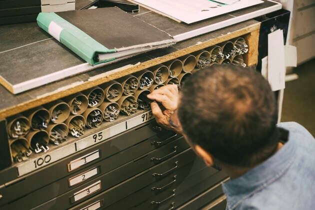 Male owner analyzing frames arranged in rack at shop Sweden, Stockholm, model released, property released Copyright: xMaskotx , MA89370