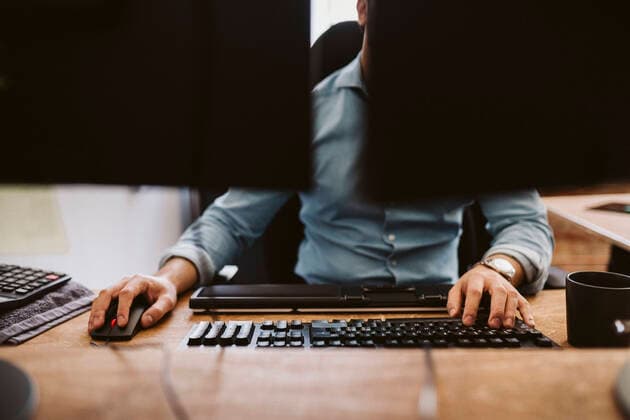Businessman using computer while sitting at desk in office Sweden, Stockholm, model released, property released Copyright: xMaskotx , MA89583