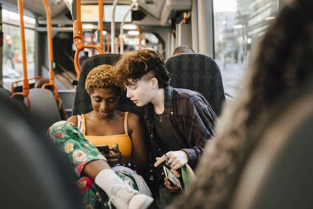 IMAGO Creative: Pride Month 2022, Engagement der Jugendlichen Teenage boy looking at young non-binary woman using smart phone in bus Sweden, Malmo, model released Copyright: xMaskotx , MA89708