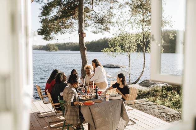 Cheerful female friends enjoying while having food at dinner party on sunny day Sweden, Gothenburg, model released, property released Copyright: xMaskotx , MA89818