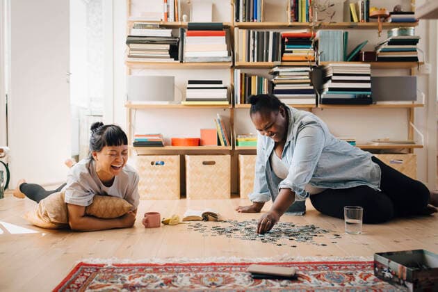 Happy female friends playing puzzle on floor at home Sweden, Stockholm, model released, property released Copyright: xMaskotx , MA90002