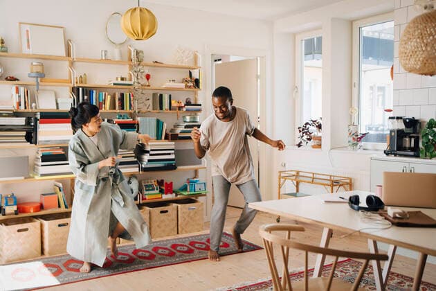 Cheerful couple dancing in living room at home Sweden, Stockholm, model released, property released Copyright: xMaskotx , MA90049