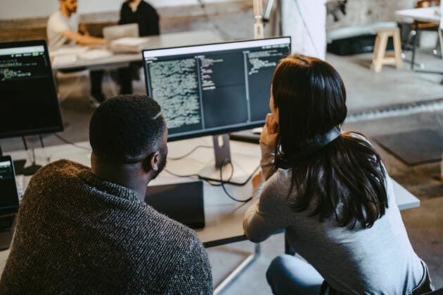 Male and female programmers coding over computer in creative office Germany, Berlin, model released, property released Copyright: xMaskotx , MA90141