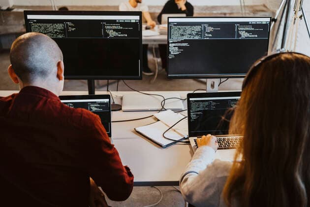 Male and female programmer doing coding over laptop in startup company Germany, Berlin, model released, property released Copyright: xMaskotx , MA90149
