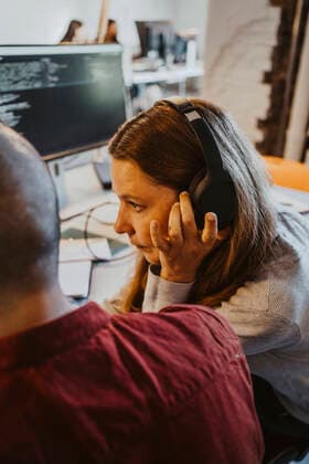 Female programmer listening through headphone while doing coding at startup company Germany, Berlin, model released, property released Copyright: xMaskotx , MA90154